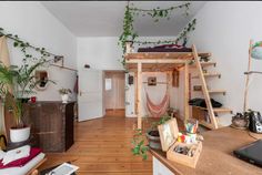 a loft bed is in the middle of a room with wooden floors and shelves on both sides