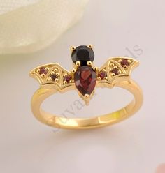 >Item Details:---- *Metal :-  925 Sterling Silver > Gem stone :-Garnet 4x6 mm  pear 1 pcs /black onyx 4mm Round 1 pcs /1.3 mm  round 6 pcs >Plating  Availability:-  White Rhodium plating/Yellow Gold Plating/Rose Gold Plating. >Product Category:-- Wedding Ring, Engagement Ring, Promise Ring, Anniversary Gift FEATURE >Purity Stamp  >  CUSTOM  ORDER<   We can create almost any ring , earrings , necklace you desire with high quality and   affordable price. please message us for details. curved weddi Gold Sterling Silver Ruby Ring For Wedding, Elegant Rings For Halloween Gifts, Gold Ruby Ring In Sterling Silver For Wedding, Elegant Rings As Halloween Gifts, Wedding Ruby Ring In Gold And Sterling Silver, Elegant Halloween Gift Ring, Elegant Halloween Ring Jewelry, Elegant Halloween Jewelry Rings, Bat Ring