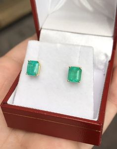 Featured here is a beautiful set of emerald cut Colombian emerald studs in fine 14K yellow gold. Displayed are medium-green emeralds with very good transparency, accented by a simple four-prong 14K gold mount, allowing for the emerald to be shown in full view. The earth mined, green Colombian emeralds have a desirable lush green color with excellent qualities. These earrings are ideal for everyday use and are the perfect accessory to any outfit. Total Carat Weight: 2.29cts Setting Style: Four Pr Emerald Cut Green Gemstone Earrings, Green Baguette Cut Earrings For Gifts, Classic Emerald Cut Emerald Earrings, Emerald Cut Green Earrings, Baguette Cut Emerald Earrings As A Gift, Emerald Cut Fine Jewelry, Emerald Cut Emerald Earrings In Yellow Gold, Emerald Cut Emerald Earrings Fine Jewelry, Emerald Studs