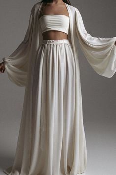 Feel the freedom going through your soul when you wear our angelic white co-ord set, crafted from high-quality materials with a semi-see-through feature. This three pant set contains high-waisted palazzo pants with wide legs and ruched fabric and has a wrap-up belt with a stretchy waistband, and it is paired with a beach cover-up long sleeve kimono and a cute bandeau tube top. We also have this palazzo set in brown, and black. Details: Top Bottom Women White Beach Kimono Tube Top Long Sleeves Pu Mode Coachella, Kimono Set, Mode Kimono, Mode Hippie, Long Sleeve Kimono, Neon Dresses, Beach Kimono, Wide Leg Palazzo Pants, Looks Street Style