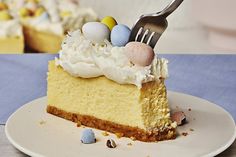 a piece of cake on a plate with a fork stuck in it and eggs around the edge