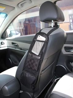 the back seat of a car with a black and white bag hanging from it's center console