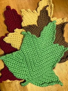 crocheted leaves laying on top of a wooden table