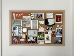 a cork board with pictures and magnets on it in front of a white wall