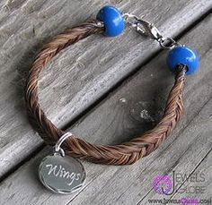 a brown bracelet with blue beads and a name tag on it is sitting on a wooden surface