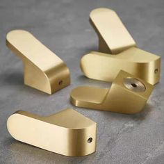 three brass door handles on a gray surface