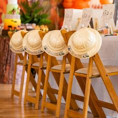 four wooden chairs with hard hats on them