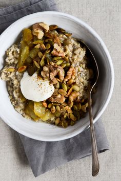 a white bowl filled with oatmeal and nuts on top of a gray napkin