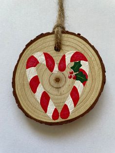 a wooden ornament decorated with candy canes and holly