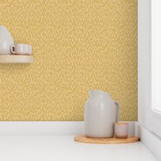 two white vases sitting on top of a counter next to a shelf filled with cups