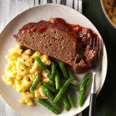 meatloaf, macaroni and green beans on a plate with a fork