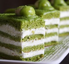 green and white layered cake with an olive on top, ready to be eaten for dessert