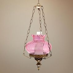 a pink glass lamp hanging from a chain