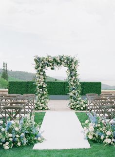 an outdoor ceremony setup with white and blue flowers