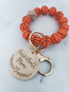 a basketball keychain with a personalized charm on it and a ball hanging from the front