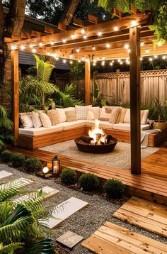 an outdoor living area is lit up with string lights and wooden benches around the fire pit