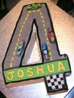 a cake shaped like the number four with cars on it