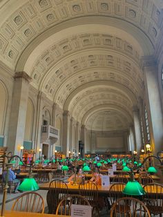 the interior of a large library with tables and chairs, green lamps on each table