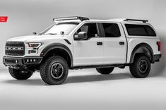 a white pick up truck parked in a studio