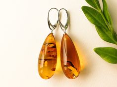 "Natural Baltic amber cognac color earrings is a perfect choice for classy style admirers! Shaped in drop form these earrings look delicate yet fancy. MATERIALS AND SIZE: Stone: 100% Natural Baltic Amber Findings: sterling silver 925 Weight: 8,5 g (0,29 oz) Bead size: 3,5 cm (1,37 in) x 1,4 cm (0,55 in) Total earring length: 5,5 cm (2,16 in) PLEASE NOTE: All our amber production is made of natural amber. Amber is an unique stone and every piece is handmade, therefore there might be some slight d Orange Teardrop Earrings For Summer, Orange Teardrop Earrings For Formal Occasions, Elegant Brown Earrings For Summer, Orange Teardrop Summer Earrings, Elegant Brown Summer Earrings, Formal Orange Teardrop Earrings, Amber Teardrop Earrings, Elegant Orange Teardrop Earrings, Light Orange Color