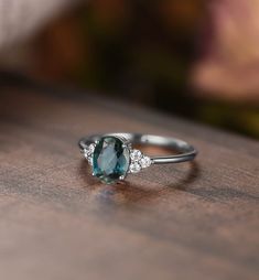 an oval cut blue diamond ring on a wooden table