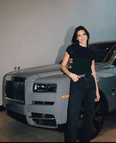 a woman standing next to a silver car