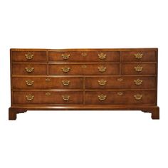 a large wooden dresser with many drawers and gold pulls on the top, against a white background