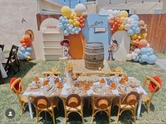 a table set up for a party with balloons