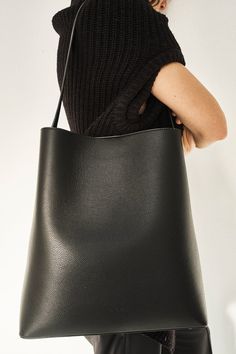 Carry-all tote crafted in supple Italian calfskin leather. A softer and slouchier version of our classic Sac. Central magnetic closure, and internal pocket. - Shoulder strap - Magnetic Closure - Interior Pocket - Composition: 100% Grain Calfskin - Lining: Polyester - Dimensions: H 35.5cm W 32 cm D 11cm - Handle drop: 33cm - Aesther Ekme embossed logo (Three dots) Sleek Textured Leather Bag For Everyday, Chic Bucket Bag With Smooth Grain For Work, Elegant Black Bucket Bag With Smooth Grain, Smooth Grain Hobo Bag In Tote Shape For Work, Smooth Grain Tote Hobo Bag For Work, Smooth Grain Hobo Bag Tote For Work, Sleek Calf Leather Shoulder Bag For Everyday Use, Workwear Soft Calf Leather Hobo Bag, Structured Leather Bucket Bag For Everyday