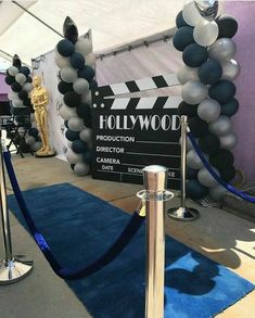 a hollywood sign and blue carpet with balloons in the shape of an oscars ribbon