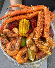 a bowl filled with seafood and corn on the cob