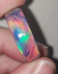 OPAREX synthetic opal is more durable and cost effective than your average opal, ensuring you will have your ring for years to come! The color shifts depending on the angle it is viewed, creating a rainbow of colors. The material is semi transparent, giving it an almost glowing effect. It is inspired by Dragon's Fire, displaying all the colors of a flame at it's hottest point. 8 mm wide This synthetic opal ring comes in a size 8 1/2 and was turned on a lathe. It is then sanded from 60 grit all t Multicolor Opal Round Ring, Iridescent Opal Ring As Gift, Multicolor Opal Ring Gift, Iridescent Opal Ring For Gift, Iridescent Opal Ring As A Gift, Iridescent Opal Ring Gift, Unique Handmade Iridescent Opal Ring, Iridescent Opal Ring Perfect For Gifts, Iridescent Opal Ring With Unique Style