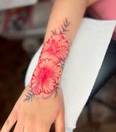 a woman's hand with a red flower tattoo on it