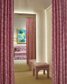 a room with pink curtains and a bench