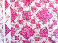 a pink and white quilt with an intricate design