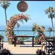 an outdoor ceremony set up with flowers on the altar and palm trees in the background