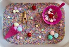 an ice cream tray with sprinkles and candies