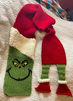 two knitted christmas stockings with the grin face on them