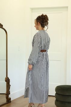 Our Walker Striped Dress is definitely a must-have item! This collarless shirt dress does have working buttons on half of the bodice. It is nursing friendly. This maxi length dress has curved side slits in the hemline which allow for walking room. - Round neckline | Collarless shirt dress - Long sleeve | Elastic cuff - Working buttons on half of bodice | Nursing friendly - Belt detail at waistline - Pockets - Maxi length - Approximately 10.5" side slits at hemline - Material: 100% Cotton Color D Spring Workwear Maxi Dress With Side Slits, Midi Maxi Dress With Side Slits For Daywear, Belted Maxi Shirt Dress For Daywear, Daywear Maxi Dress With Buttons, Buttoned Maxi Dress For Daywear, Buttoned Midi Length Maxi Dress For Daywear, Long Sleeve Maxi Dress With Side Slits For Daywear, Midi Length Button Back Dress For Daywear, Long Sleeve Dresses With Side Slits For Daywear