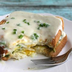 an egg and cheese sandwich on a plate with a fork