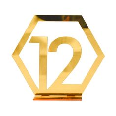 a gold sign with the number twelve in it's center on a white background