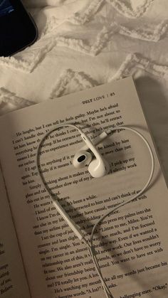 an open book with headphones laying on top of it