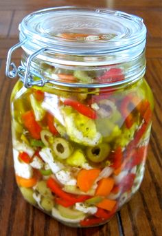 a glass jar filled with pickles and peppers