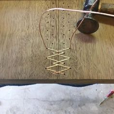 a pair of scissors and some wire on a wooden table next to an old hammer