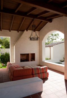 an outdoor living area with couches and a fireplace