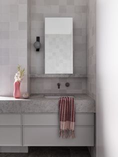 a bathroom with a sink, mirror and towel on the counter