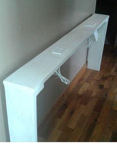 a white console table with an electrical outlet plugged into it