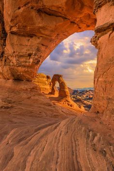 an arch in the side of a mountain with rocks and dirt on it's sides