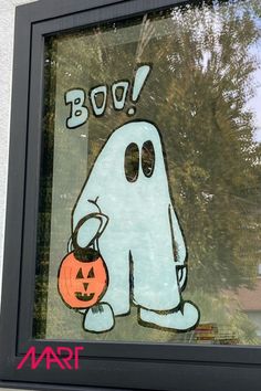 a window with a ghost holding a pumpkin