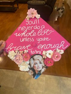 a pink graduation cap decorated with flowers and an image of a woman's face